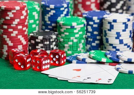 Dice, Four Aces And Colorful Poker Chips On A Green Felt