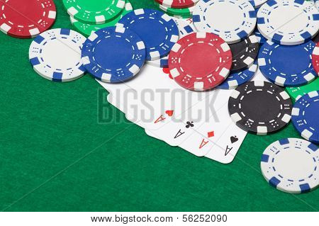 Poker Chips And Four Aces On A Green Table Background