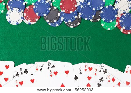 Poker Chips And Cards On A Green Table Background