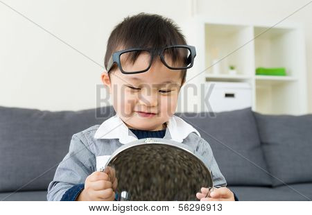 Asian little boy using mirror