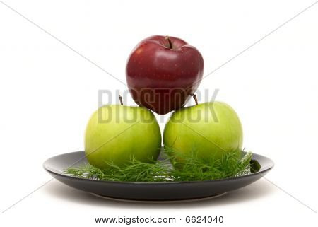 Tre äpplen på en tallrik