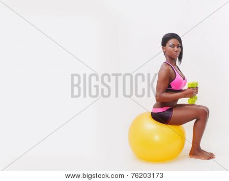 Attractive Woman Training With Workout Ball And Weights