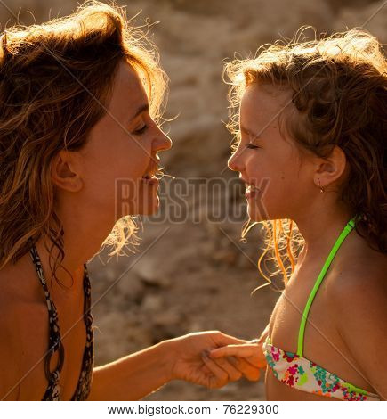 Loving moments of mother and child. Mom and girl on sunset