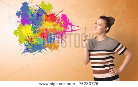 Cute girl blowing bubble spalsh graffiti into wall