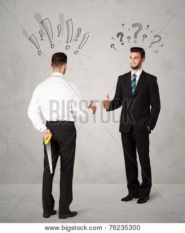Ruthless businessman handshake with drawn exclamation and question marks around them head