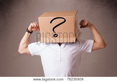Young man standing and gesturing with a cardboard box on his head with question mark