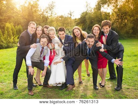 Newlyweds with guest posing in park