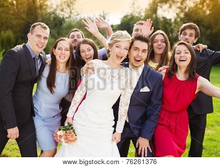 Newlyweds with guest posing in park