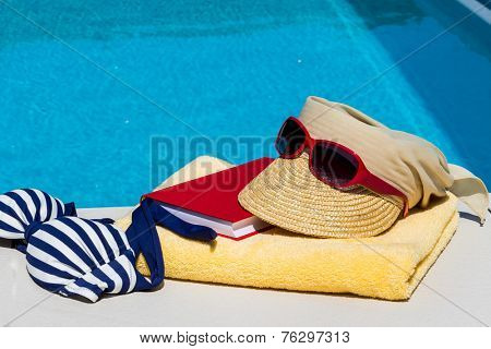 utensils for a nice and relaxing vacation day lying next to a swimming pool. relaxation on holiday.