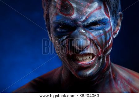 A creepy portrait of a halloween man with face art.
