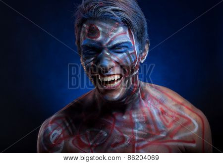 A creepy portrait of a halloween man with face art.