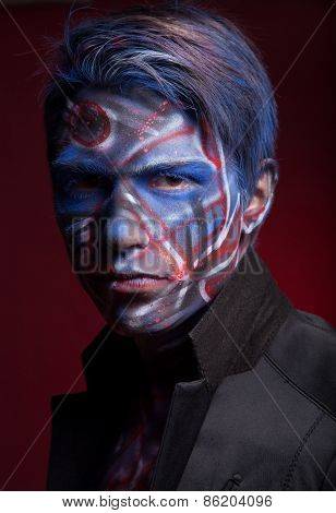 A creepy portrait of a halloween man with face art.