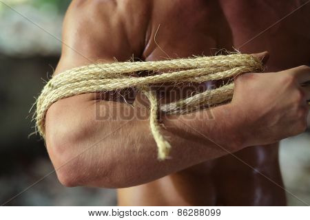 young guy pulls rope on hand in abandoned building, fragment 