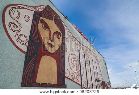 Face Of Local Woman With National Patterns On The Wall.