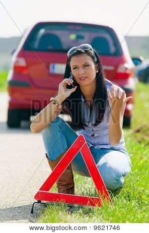 Žena s červený výstražný trojúhelník pro případ poruchy