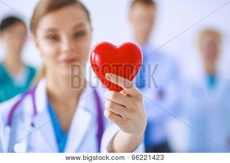 Female doctor with stethoscope holding heart .