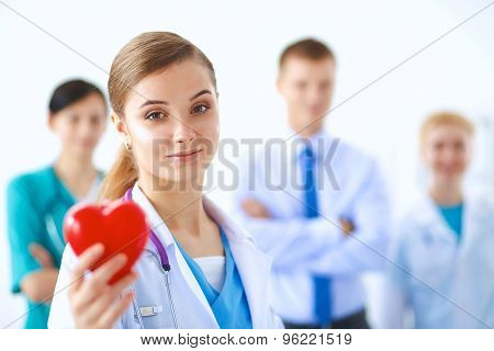 Female doctor with stethoscope holding heart .