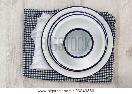 Vintage Enamelware Crockery On Retro Cloths On Rustic Wooden Background
