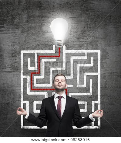 Meditative Businessman And Solved Labyrinth With A Light Bulb On The Black Chalk Board.
