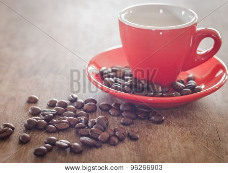 Red Coffee Cup With Coffee Beans On Wooden Table