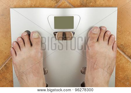 Man looks at a personal scale. Look on her toes, diseased nails. Koncept reducing body weight and di