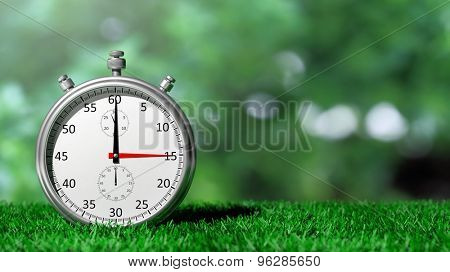 Silver chronometer on green grass