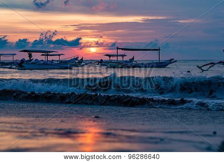 traditional Balinese ships Jukung close on Sanur beach at sunrise, Bali, Indonesia
