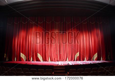red theater curtain with embroidery stretched on a scene of theatre