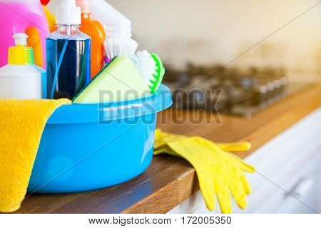 Basket with cleaning items on blurry background white citchen. Cleaning concept. Set with copy space.
