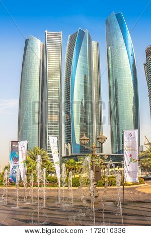 Abu Dhabi, United Arab Emirates - April 21, 2013: Etihad Towers seen from Emirates Palace with splash of water. Etihad Towers, a complex of buildings with five towers. Finance and business concept.