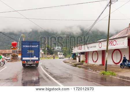 KINTAMANI INDONESIA - January 26 2013. Heavy fog on the road bad weather for driving motorbike. Road through misty evergreen jungle forest. Winter rainy season. Indonesia.
