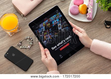 Alushta Russia - November 17 2016: Woman holding iPad Pro Space Gray with multinational entertainment company Netflix provides streaming media and video on the screen.