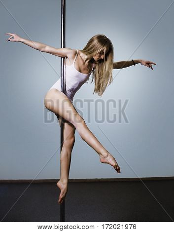 Young sexy pole dance woman. Performance on pole