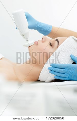 Brushing, brush-peeling. Brossage. Nozzle polishing stone. Model with closed eyes, profile. Cosmetological clinic, procedures Healthcare clinic cosmetology