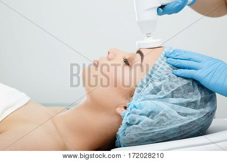Brushing, brush-peeling. Brossage. Nozzle polishing stone. Model with closed eyes. Cosmetological clinic, procedure. Profile close-up Healthcare clinic cosmetology