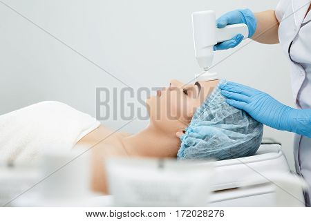 Brushing, brush-peeling. Brossage. Nozzle polishing stone. Model with closed eyes. Cosmetological clinic, procedure. Profile Healthcare clinic cosmetology