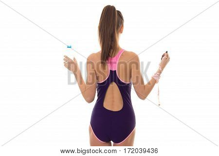 slim young brunette woman in magenta body swimsuit with sexy round butt posing with water bottle nad measure tape isolated on white