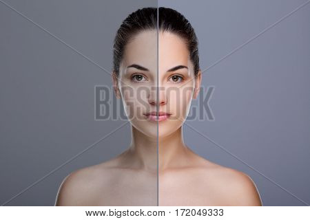 Comparison portrait of woman. Divided face of woman. One half of face with acne, before. Another half of face with retouch, after. Studio, head and shoulders, indoors. Gray background