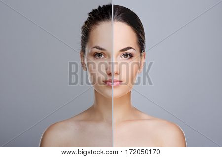 Comparison portrait of woman. Divided face of woman with perfect skin. One half of face without make-up, before. Another half of face with make-up, after. Studio, head and shoulders, indoors. Gray background