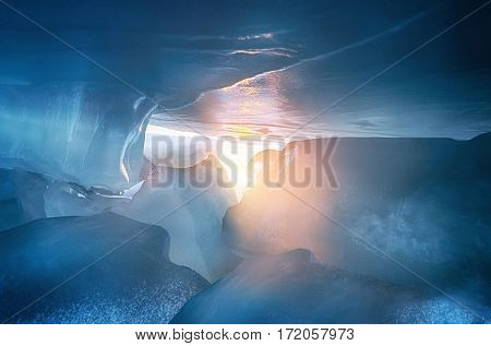 The view from the cave with icicles, shards of ice and incrustations on the blue ice of lake Peipsi. Spring drops, natural background. Estonia