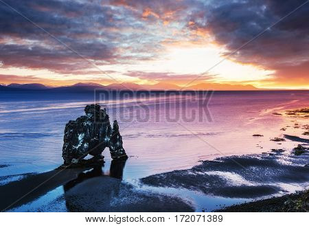 Hvitserkur is a spectacular rock in the sea on the Northern coast of Iceland. Legends say it is a petrified troll. On this photo Hvitserkur reflects in the sea water after the midnight sunset.