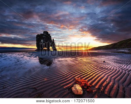 Hvitserkur is a spectacular rock in the sea on the Northern coast of Iceland. Legends say it is a petrified troll. On this photo Hvitserkur reflects in the sea water after the midnight sunset.