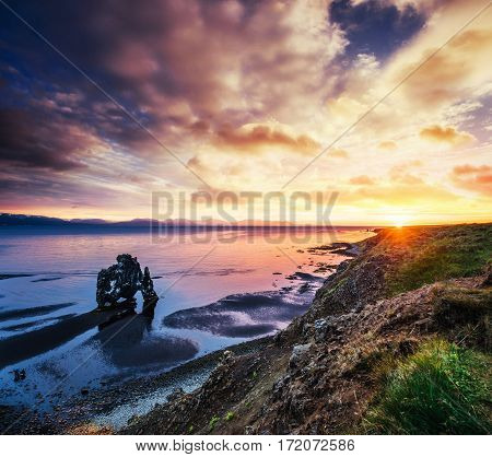Hvitserkur is a spectacular rock in the sea on the Northern coast of Iceland. Legends say it is a petrified troll. On this photo Hvitserkur reflects in the sea water after the midnight sunset.