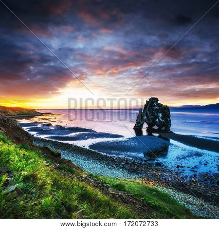 Hvitserkur is a spectacular rock in the sea on the Northern coast of Iceland. Legends say it is a petrified troll. On this photo Hvitserkur reflects in the sea water after the midnight sunset.