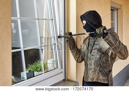 Burglar trying to break into a house with a crowbar