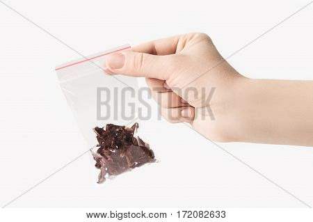 Hand holding Plastic transparent zipper bag with half carcade tea isolated on white, Vacuum package mockup with red clip. Concept