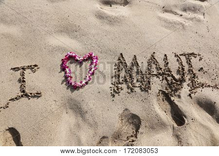 I LOVE Maui. the words I love maui written in sand on the beach with a Hawaiian lei for the heart symbol of love. 