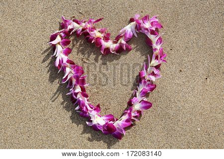 Hawaiian lei. Hawaiian lei on sand on the beach in a heart shaped designs.