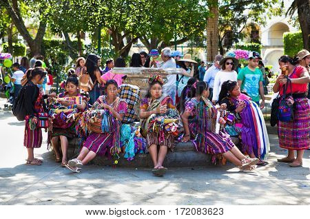 ANTIGUA, GUATEMALA-DEC 27, 2015: : Guatamalian woman selling traditional  colorful fabric and goods at the street in Antigua, on Dec 27, 2015, Guatemala.