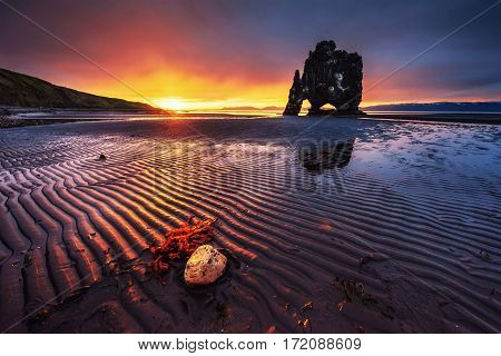 Hvitserkur is a spectacular rock in the sea on the Northern coast of Iceland. Legends say it is a petrified troll. On this photo Hvitserkur reflects in the sea water after the midnight sunset.